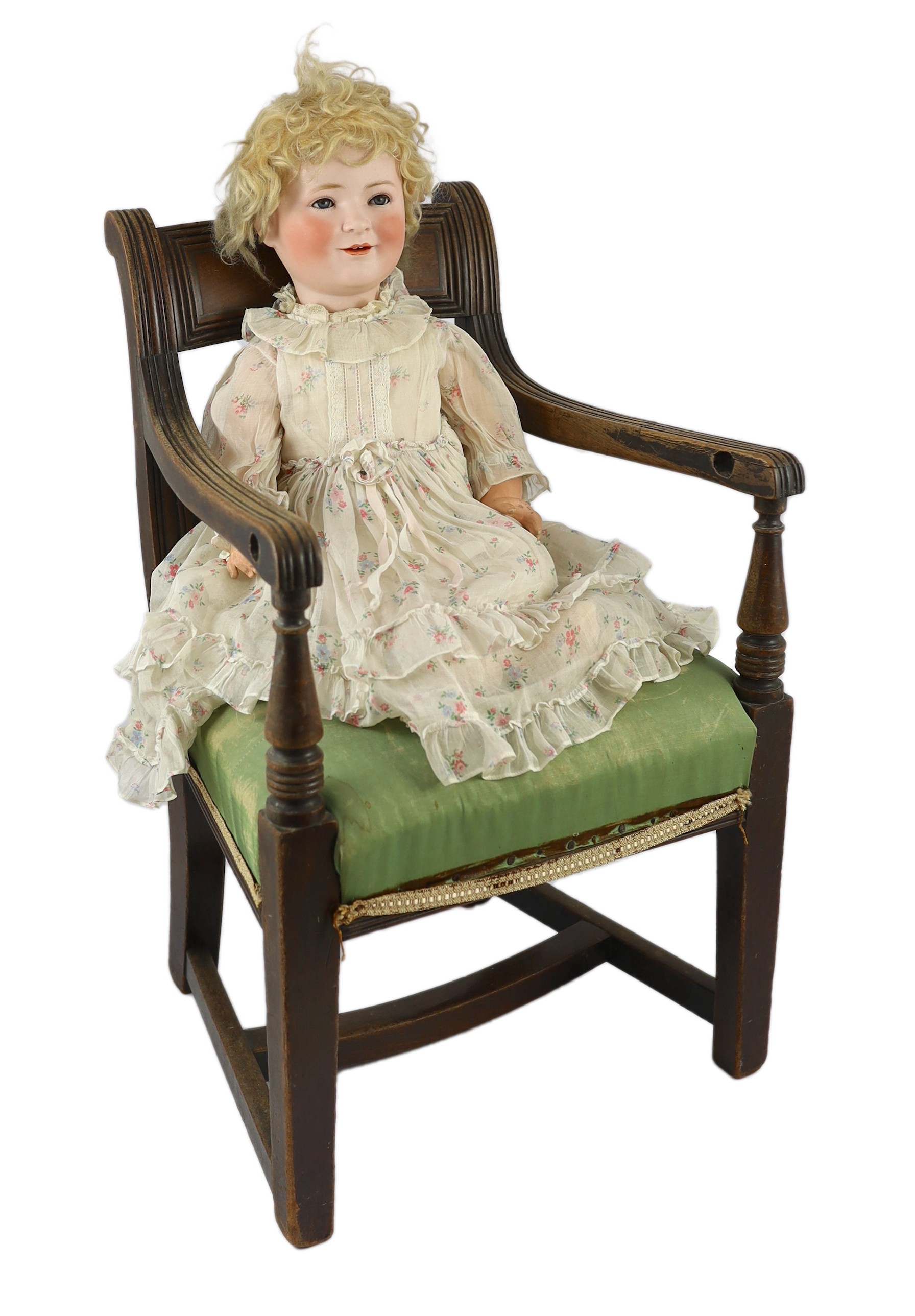 A Schoenau & Hoffmeister bisque 'Princess Elizabeth' doll, German, circa 1928, 21in. Please note the chair is for display purposes only.